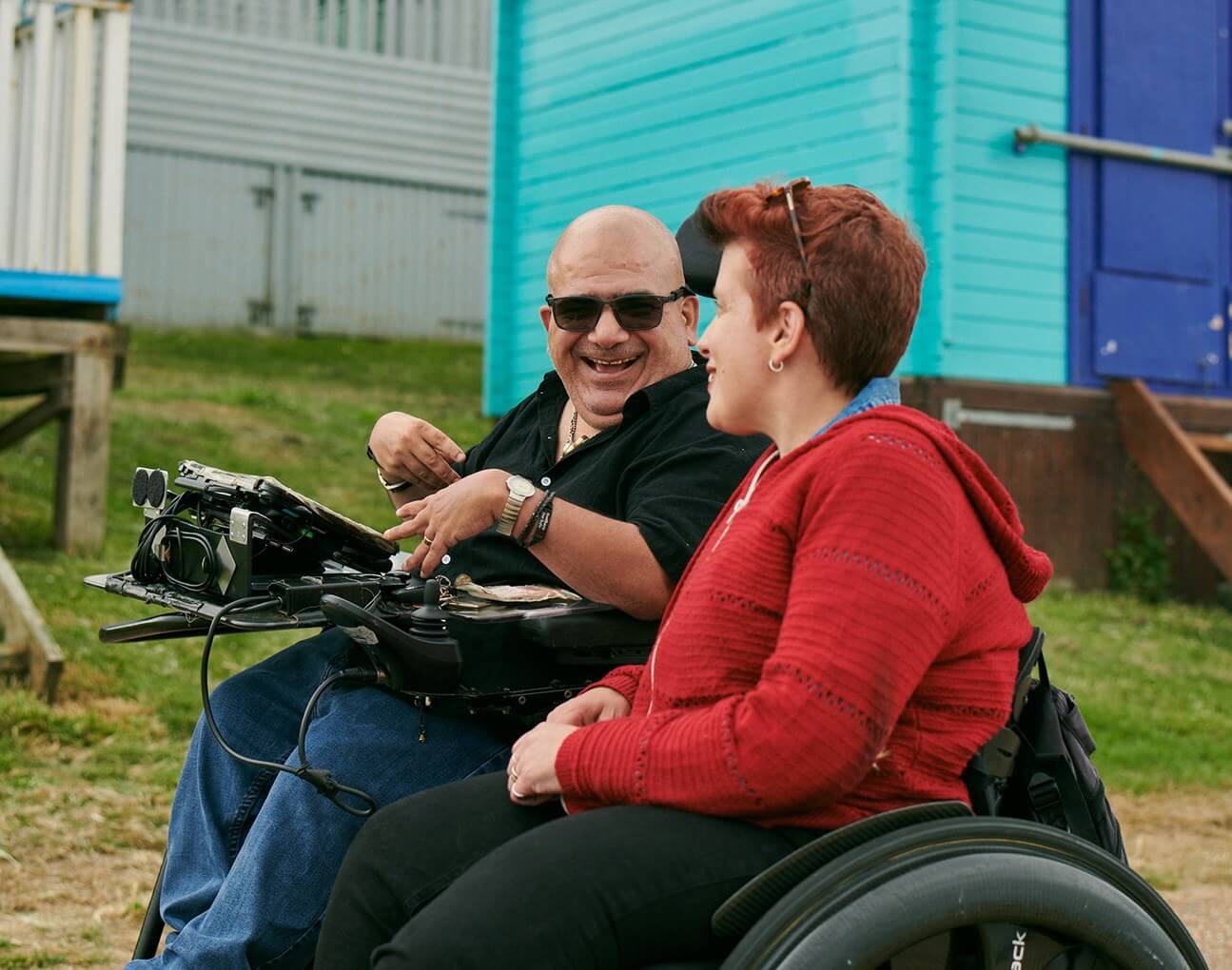 two wheelchair users talking to one another outside