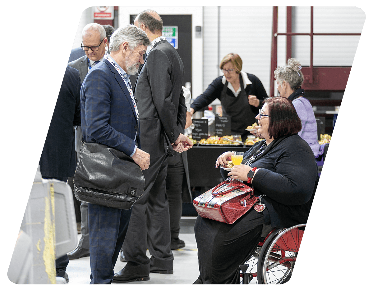 keith richards, chair of ncat board, speaking to a wheelchair user at an event