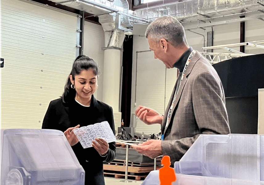 MP Zara Sultana stood with member of NCAT at event, looking at display models of vehicles