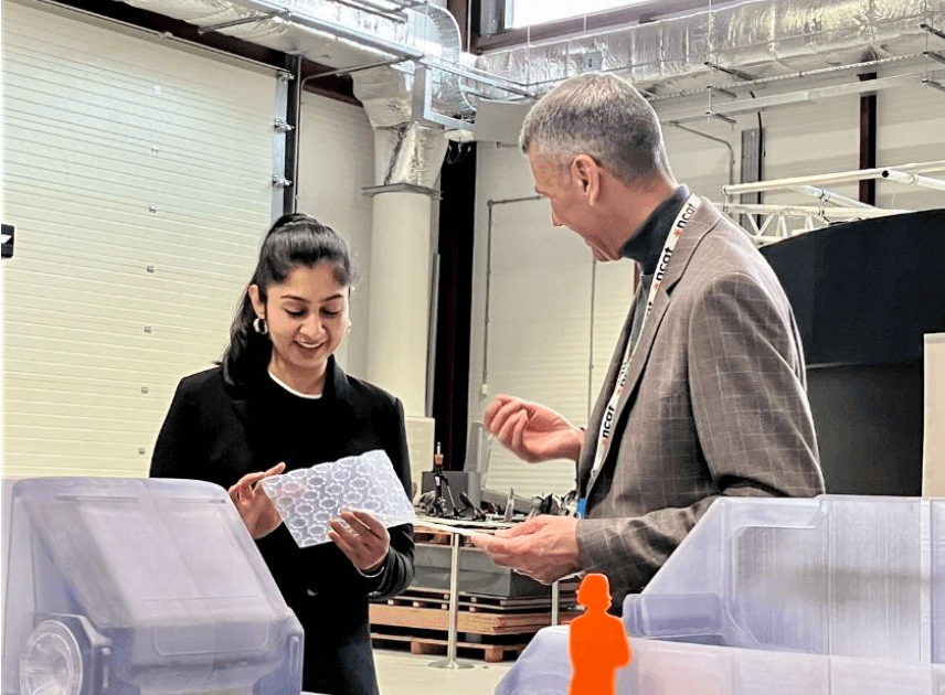 MP Zara Sultana stood with member of NCAT at event, looking at display models of vehicles