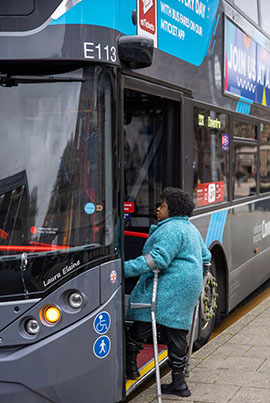 woman using mobility aids stepping onto double decker bus