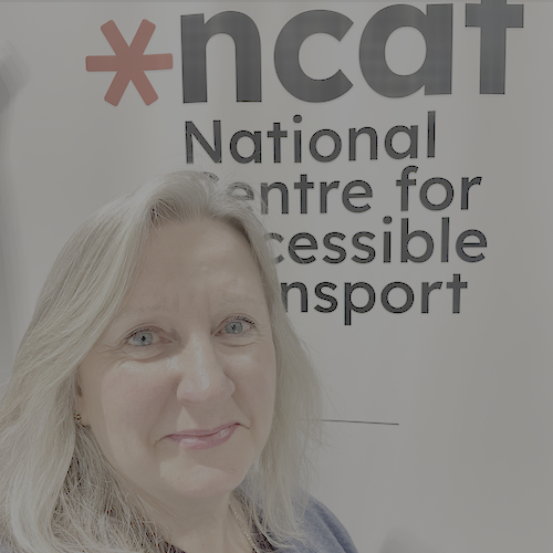 Cathryn Thompson-Goodwin headshot in front of large ncat logo and National Centre for Accessible Transport written on a poster behind her